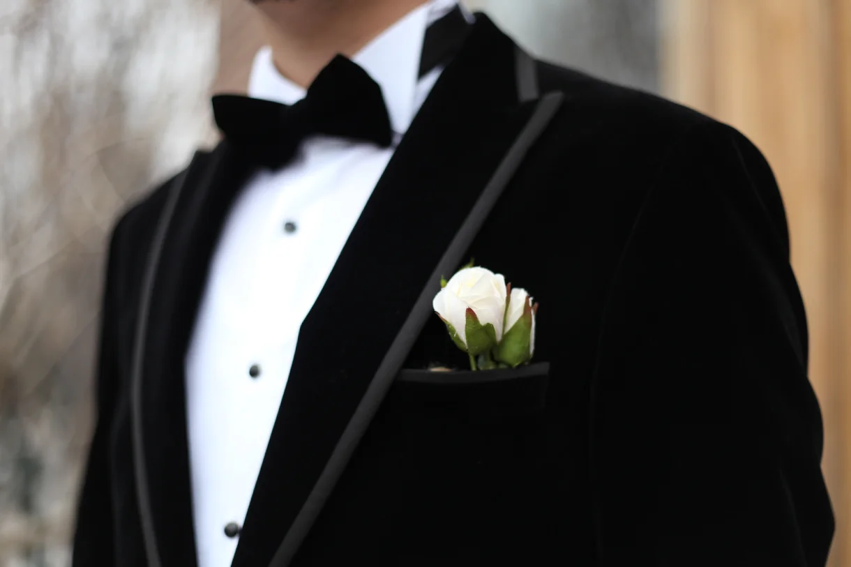 Man wearing a black tuxedo with bow tie and boutonniere